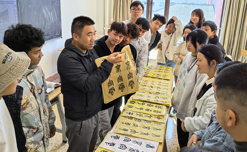 徐润刚用手语为学生们讲解书法篆刻。伟德bv国际体育供图